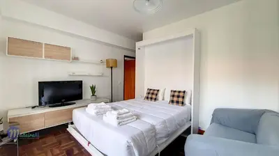 a bedroom with a bed and a tv and a chair at Linda´s Studio in Funchal