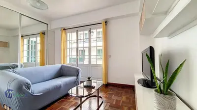 a living room with a blue couch and a tv at Linda´s Studio in Funchal