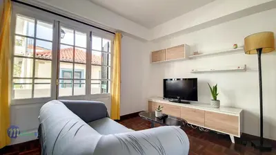 a living room with a white couch and a tv at Linda´s Studio in Funchal