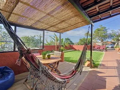 a hammock on the patio of a house at Alojamento Funchal - Silvestre House in Funchal