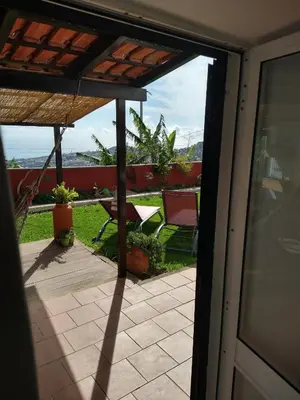 an open door to a patio with a table and chairs at Alojamento Funchal - Silvestre House in Funchal