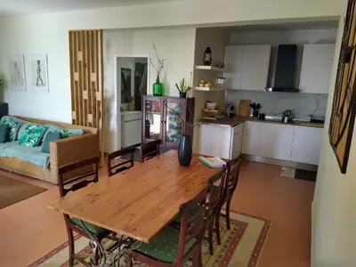 a kitchen and living room with a wooden table and chairs at Alojamento Funchal - Silvestre House in Funchal