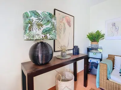 a living room with a table with a lamp at Alojamento Funchal - Silvestre House in Funchal