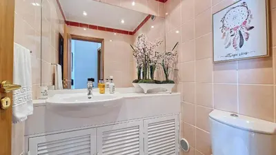 a bathroom with a sink and a toilet and a mirror at Glorious Apartment by LovelyStay in Funchal