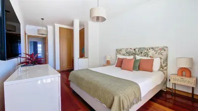 a white bedroom with a bed and a flat screen tv at Glorious Apartment by LovelyStay in Funchal