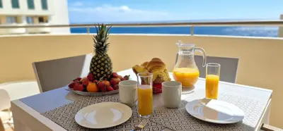 a table with a bowl of fruit and orange juice at Glorious Apartment by LovelyStay in Funchal