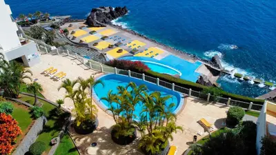 an aerial view of a resort with a pool and the ocean at Glorious Apartment by LovelyStay in Funchal