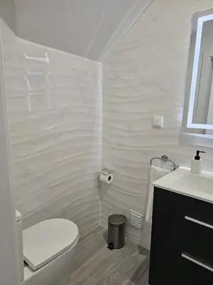 a white bathroom with a toilet and a sink at Casa D´Aldeia - Carrapateira in Aljezur