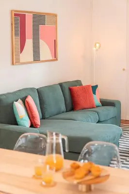 a living room with a green couch and a table at Santa Cruz I by An Island Apart in Santa Cruz