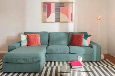 a green couch in a living room with a table at Santa Cruz I by An Island Apart in Santa Cruz