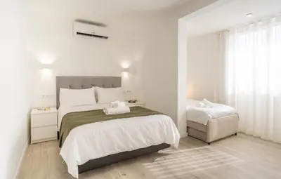 a white bedroom with two beds and a window at Sunset house in Paul do Mar