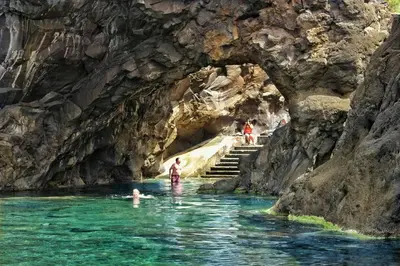 a group of people in the water in a cave at Sunset house in Paul do Mar