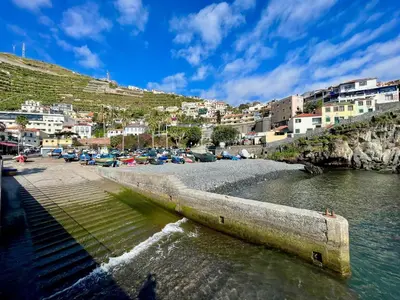 a bridge over a river with buildings on a hill at Sunset house in Paul do Mar