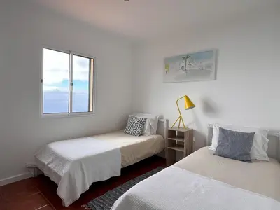 two beds in a white room with a window at Casa da Ovelha I Madeira in Fajã da Ovelha