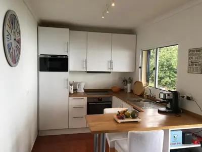 a kitchen with white cabinets and a wooden counter top at Casa da Ovelha I Madeira in Fajã da Ovelha