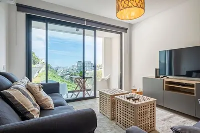 a living room with a couch and a large window at CENTRAL LOCATION - WITH POOL in Funchal