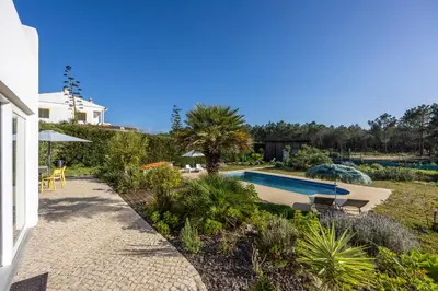 a garden with a swimming pool and a house at Villa Natureza in Aljezur