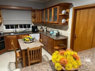 a kitchen with a table with a bowl of fruit on it at Spring House AL in Arco da Calheta