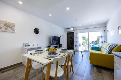 a living room with a table and a yellow couch at Waterside Village - Oceanview Dream in Luz