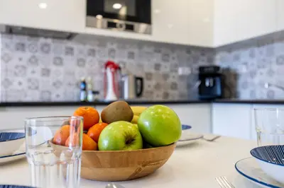 a bowl of fruit on a table in a kitchen at Waterside Village - Oceanview Dream in Luz
