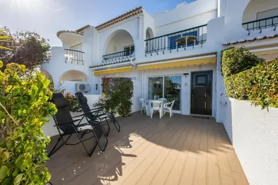 a house with a deck with chairs and a table at Waterside Village - Oceanview Dream in Luz