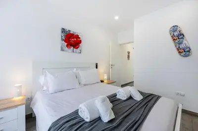 a bedroom with a white bed with towels on it at Waterside Village - Oceanview Dream in Luz