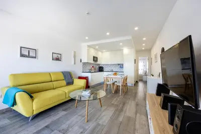 a living room with a yellow couch and a table at Waterside Village - Oceanview Dream in Luz