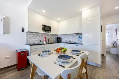 a kitchen with a white table and chairs at Waterside Village - Oceanview Dream in Luz