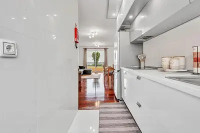 a kitchen with white counters and a white counter top at Cozy Seaside Apartment Near Beach and Airport in Caniço