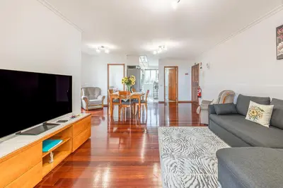 a living room with a large flat screen tv at Cozy Seaside Apartment Near Beach and Airport in Caniço