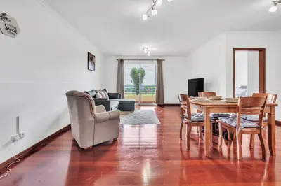 a living room with a table and chairs and a couch at Cozy Seaside Apartment Near Beach and Airport in Caniço