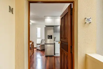 an open door to a kitchen with a refrigerator at Cozy Seaside Apartment Near Beach and Airport in Caniço