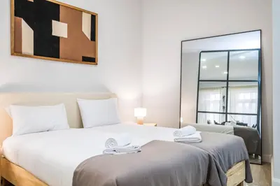 two beds in a room with a mirror at Ponte Nova Studios in Funchal
