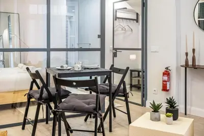 a dining room with a table and chairs and a bed at Ponte Nova Studios in Funchal