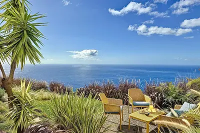 a patio with chairs and a table and the ocean at Villa OceanAIR by LovelyStay in Prazeres