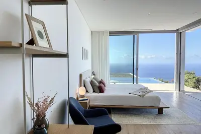 a bedroom with a bed and a view of the ocean at Villa OceanAIR by LovelyStay in Prazeres