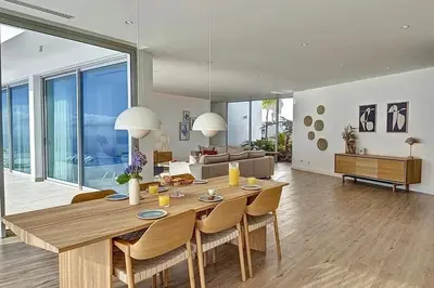 a dining room and living room with a table and chairs at Villa OceanAIR by LovelyStay in Prazeres