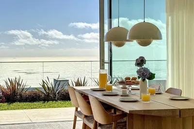 a dining room table with a view of the ocean at Villa OceanAIR by LovelyStay in Prazeres