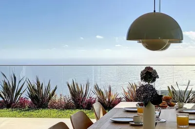 a dining table with a view of the ocean at Villa OceanAIR by LovelyStay in Prazeres