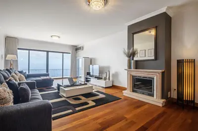 a living room with a couch and a fireplace at Faias Haven by Homie in Arco da Calheta