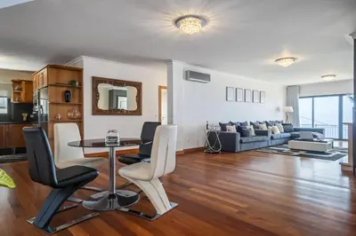 a living room with a table and chairs and a couch at Faias Haven by Homie in Arco da Calheta