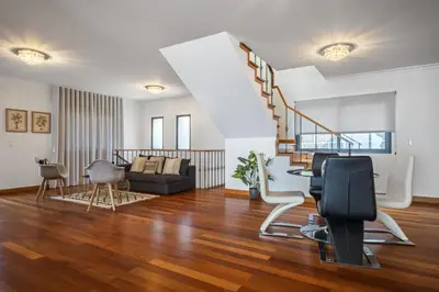 a living room with a staircase and a couch at Faias Haven by Homie in Arco da Calheta