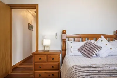 a bedroom with a bed and a nightstand with a lamp at Faias Haven by Homie in Arco da Calheta