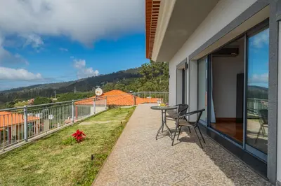 a patio with a table and chairs on a balcony at Faias Haven by Homie in Arco da Calheta