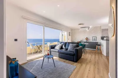 a living room with a couch and a view of the ocean at Portinho Mar Apartment in Caniço