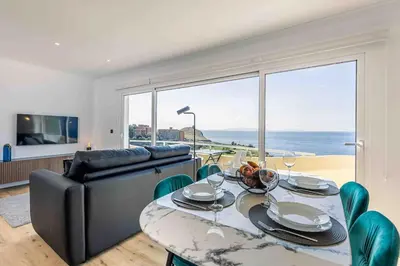 a living room with a table and a couch at Portinho Mar Apartment in Caniço