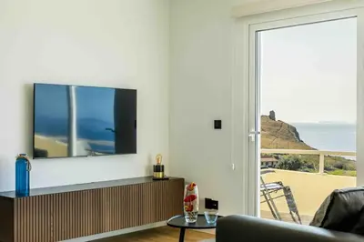 a living room with a flat screen tv on a wall at Portinho Mar Apartment in Caniço