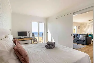 a bedroom with a bed with a view of the ocean at Portinho Mar Apartment in Caniço