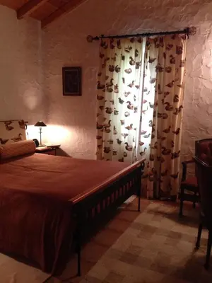 a bedroom with a bed and a window with curtains at Moinho do Comandante in Faial