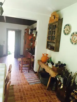a living room with a table and a kitchen at Moinho do Comandante in Faial